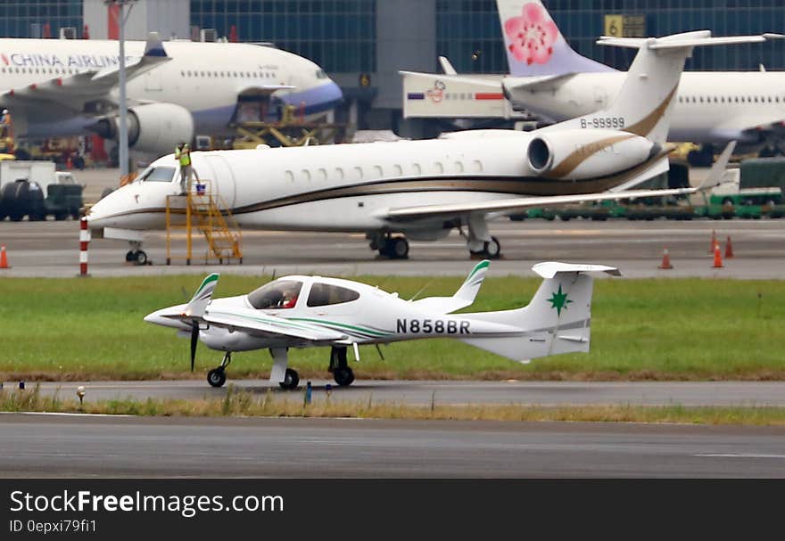 Commercial, corporate and small aircraft on busy international airport runway. Commercial, corporate and small aircraft on busy international airport runway.