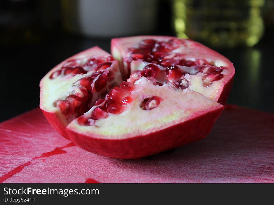 A halved pomegranate fruit on a cutting board. A halved pomegranate fruit on a cutting board.