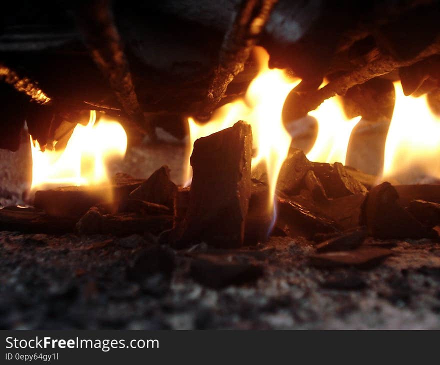 A burning wood fire with red embers and charcoal.