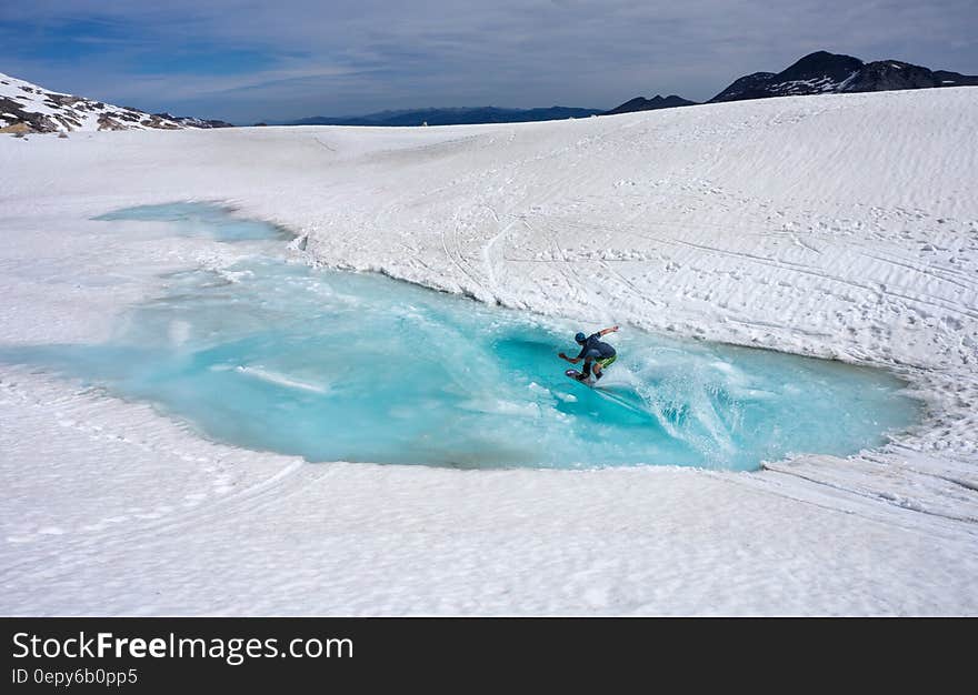 Person Riding on Snowboard during Daytime