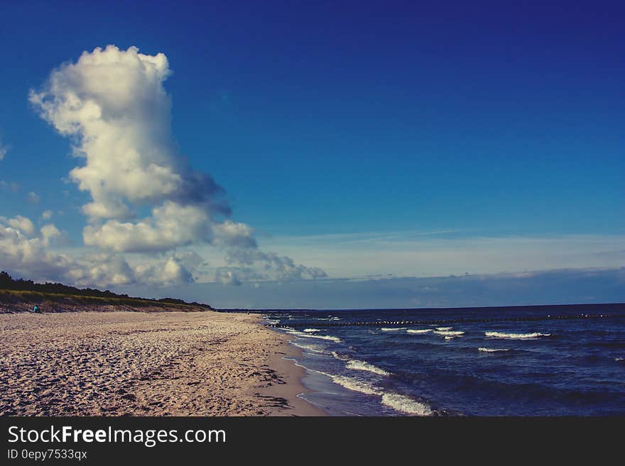 Bodies of Water Beside Sand on White Clouds and Blue Sky