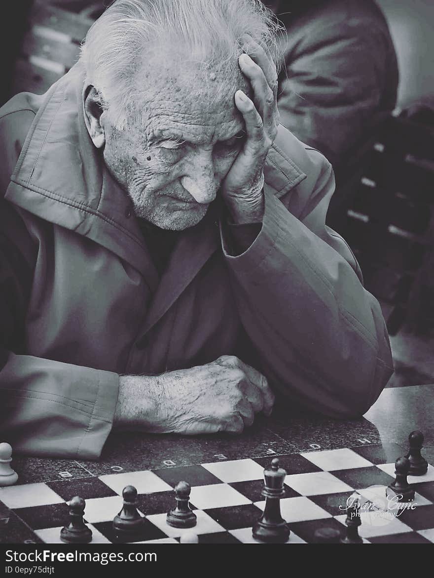 Grayscale Photo of Man Playing Chess