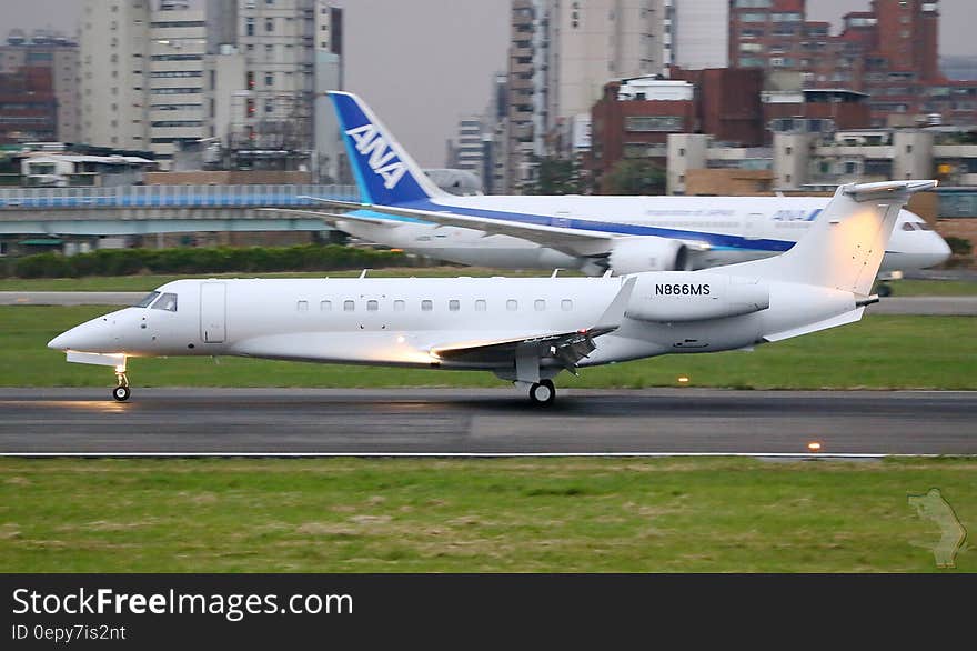 Commercial and corporate jets on runway outside terminal building in international airport. Commercial and corporate jets on runway outside terminal building in international airport.