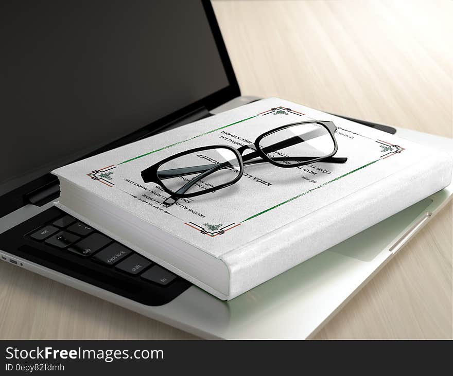 Black Frame Eyeglasses on White Book