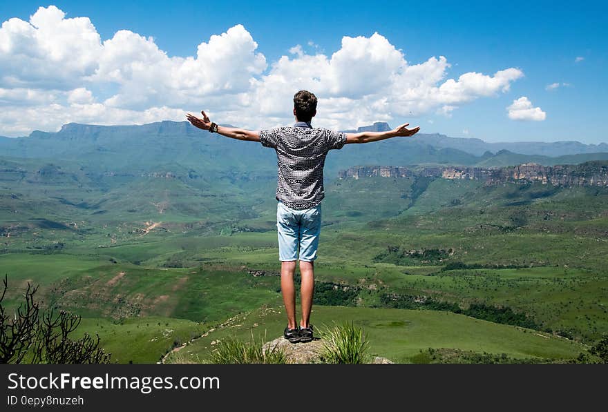 Man Wearing Grey Shirt Standing on Elevated Surface