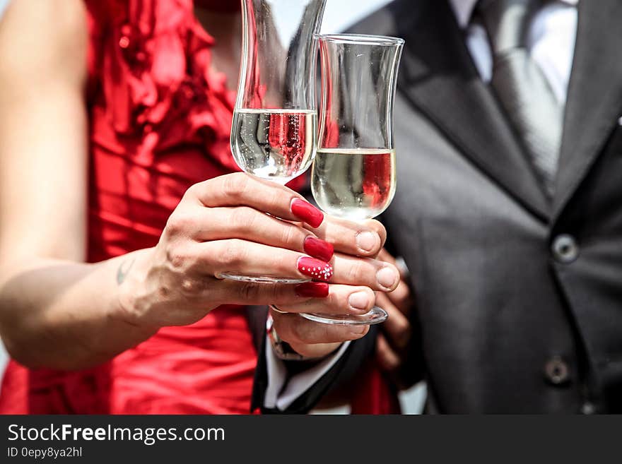 Hands and bodies of newly married couple toasting with champagne glasses.