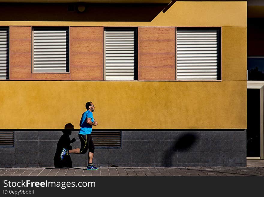 Jogging Man Wearing Blue Shirt during Daytime