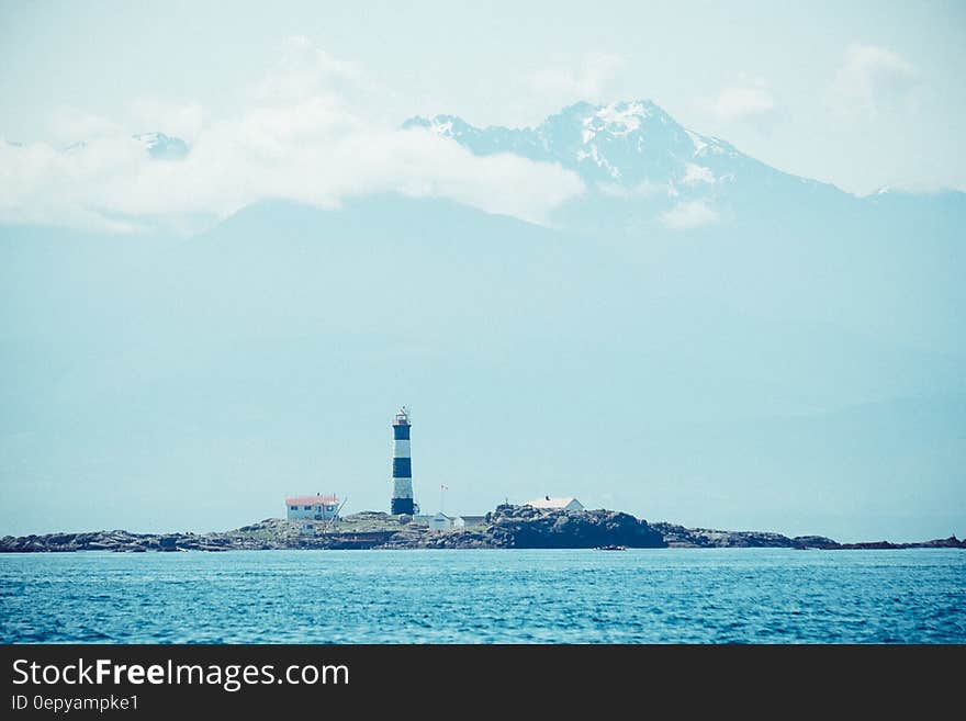 Blue Ocean Near in Black and White Lighthouse during Daytime