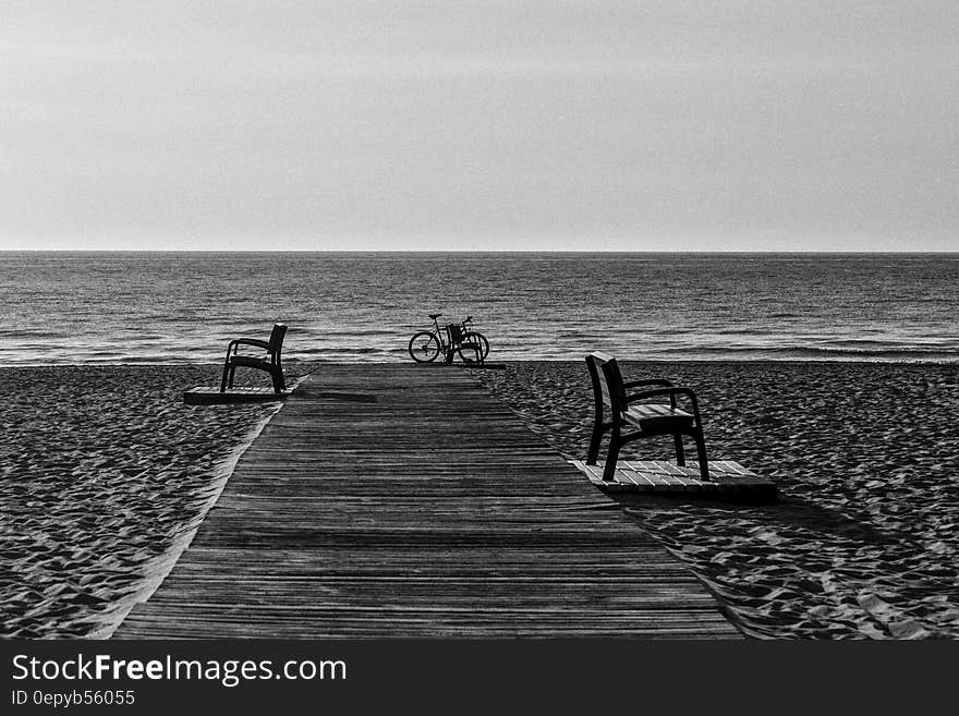 Grayscale Photo of Bicycle Beside Seashore