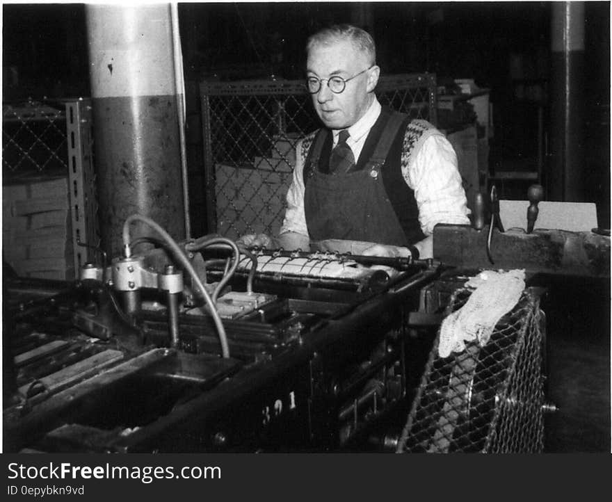 Black and white portrait of mature worker in factory with machinery in foreground. Black and white portrait of mature worker in factory with machinery in foreground.