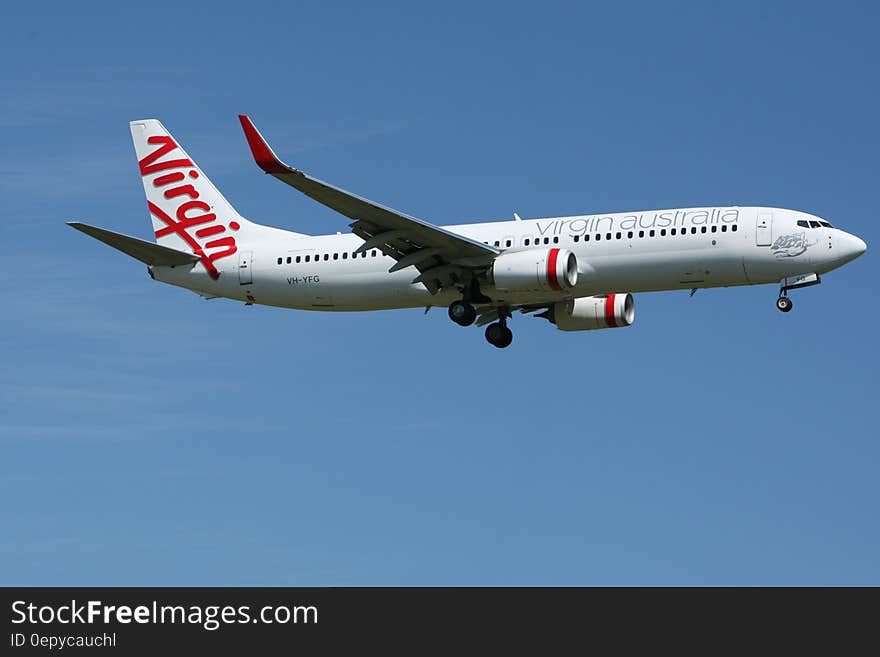 White and Red Virgin Australia Airplane Mid Air Under Blue and White Sky during Daytime