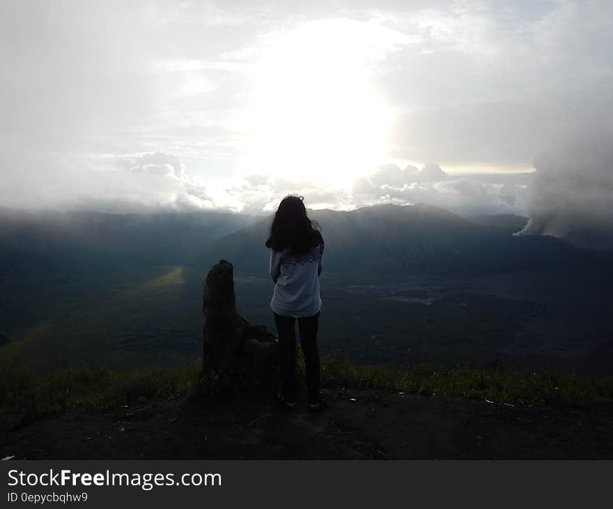 Woman Staing at the Edge of the Mountain Facing the Sun