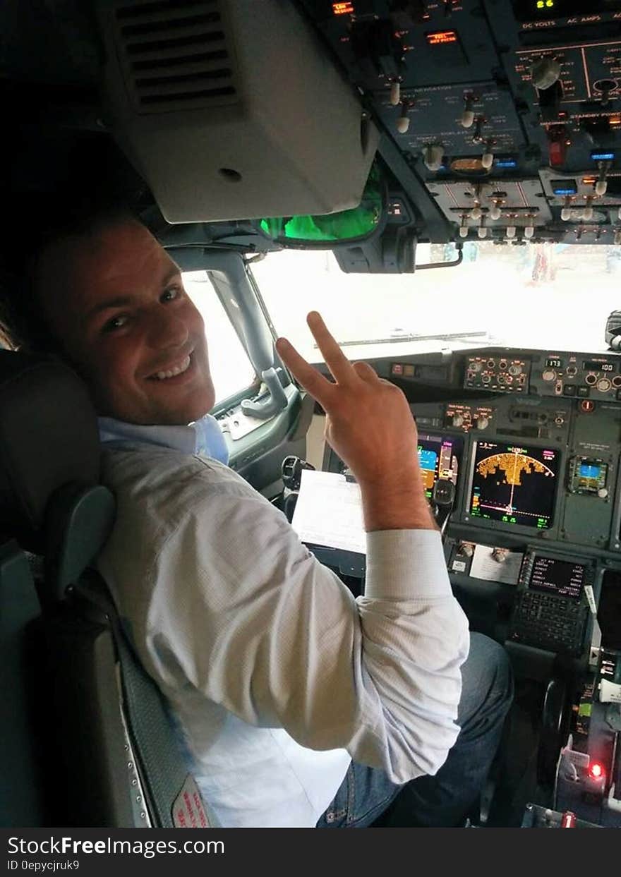 Pilot gesturing and smiling in airplane cockpit. Pilot gesturing and smiling in airplane cockpit.