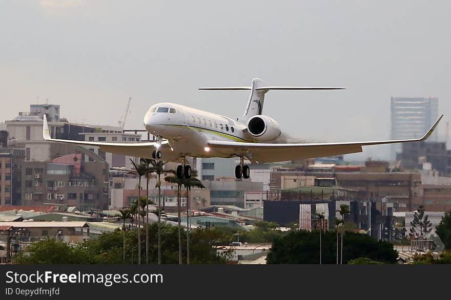 Airplane landing over urban area at airport.