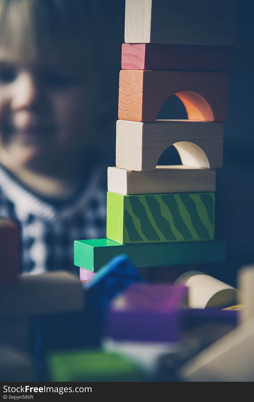 Selective Focus Photography of Beige Orange Red and Green Blocks Piled Vertically