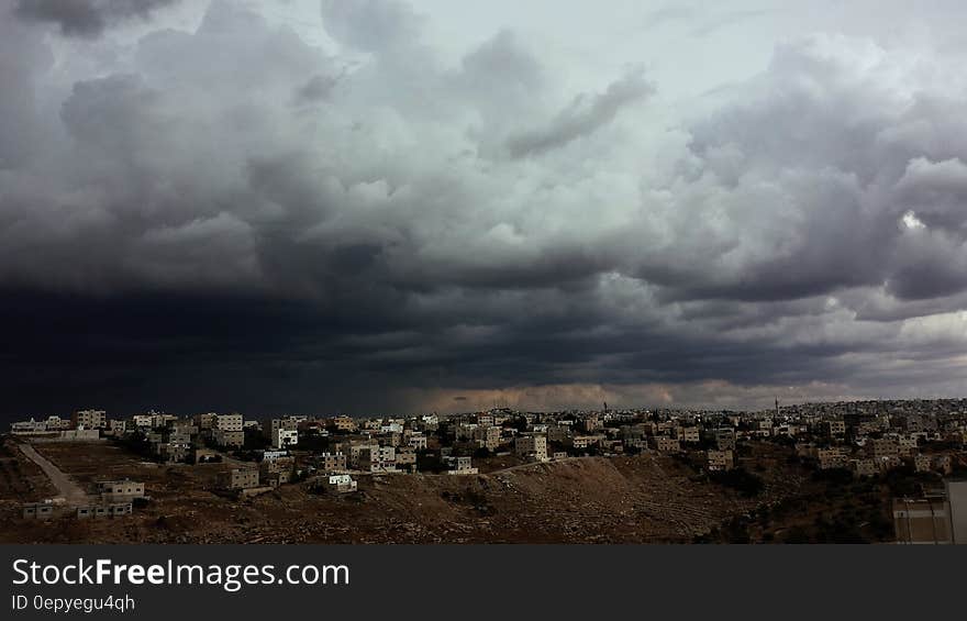 White Concrete Buildings Under Cloudy Sky