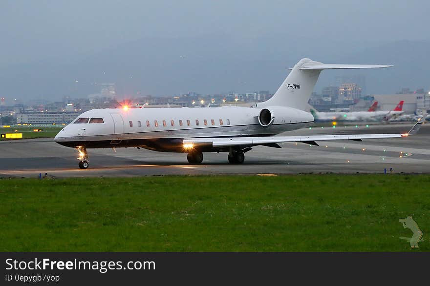 Private jet on taxiway at airport at twilight. Private jet on taxiway at airport at twilight.