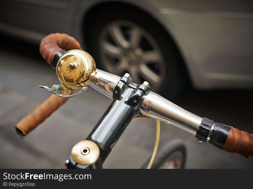 Close up of bell on bicycle handlebar on streets.