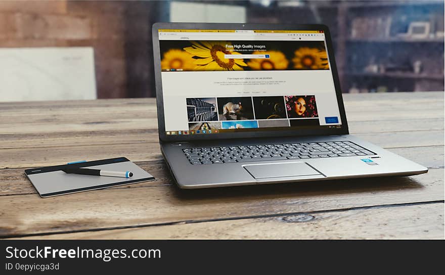 Laptop computer open on wooden table inside room. Laptop computer open on wooden table inside room.