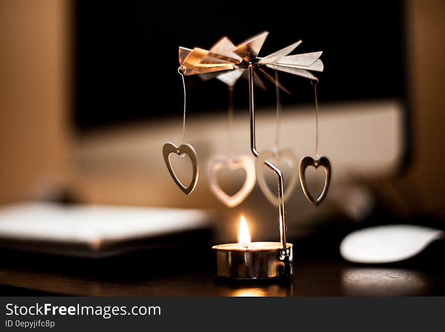 Roundabout with windmill blades driven by heat and convection from lighted candle. Attached to windmill are heart shapes hanging down. Roundabout with windmill blades driven by heat and convection from lighted candle. Attached to windmill are heart shapes hanging down.