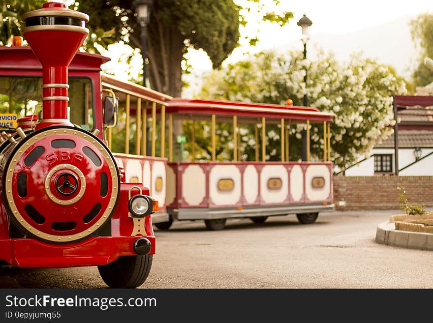 Red and cream tourist train on wheels designed for sight seeing by adults and children.