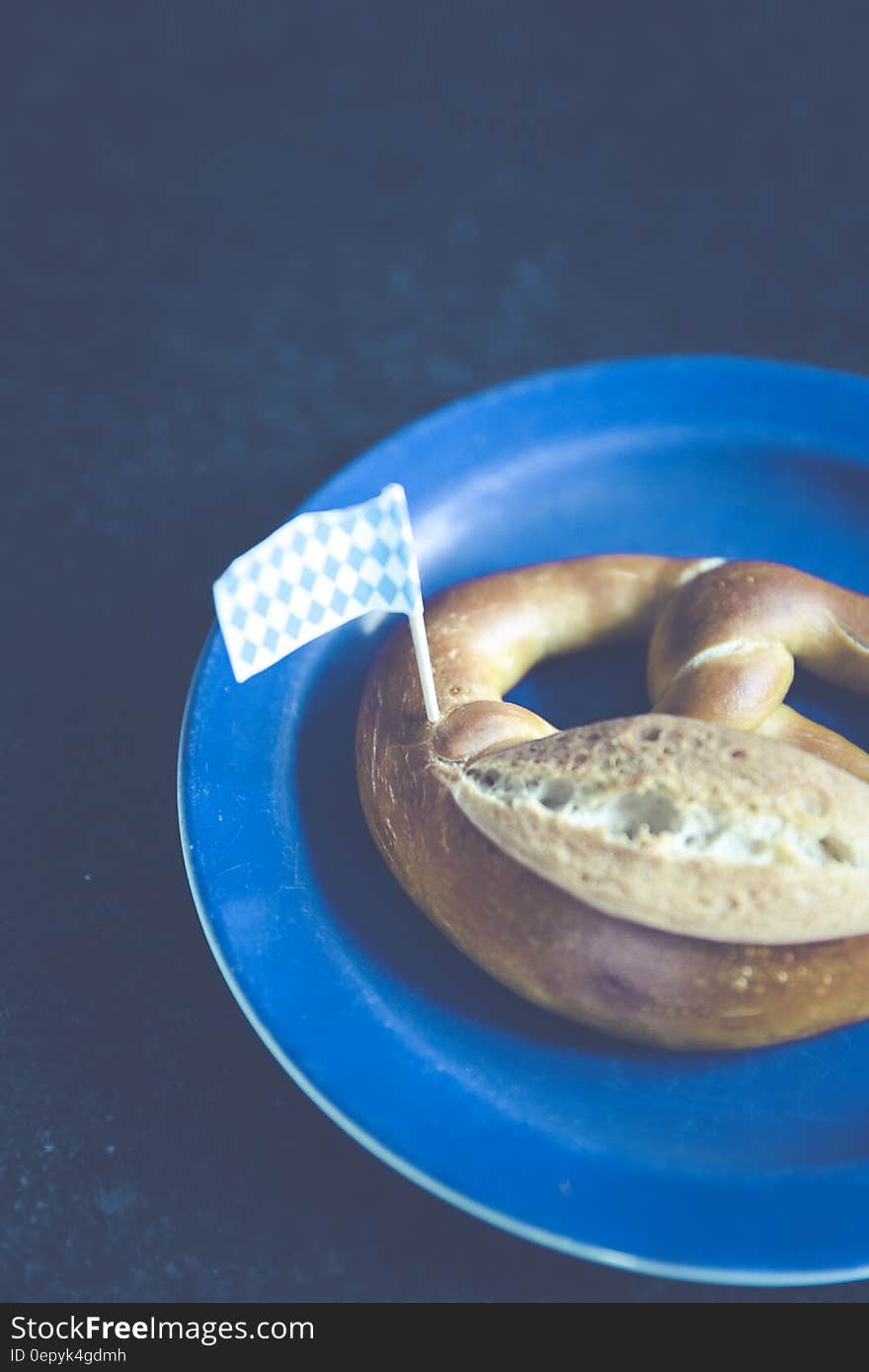 White and Blue Plastic Flag on Pastry on Blue Plastic Plate