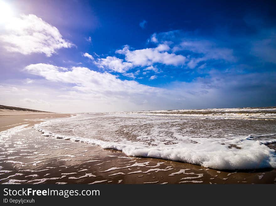 Bike Waves of Sea Under Clouded Blue Sky during Daytime