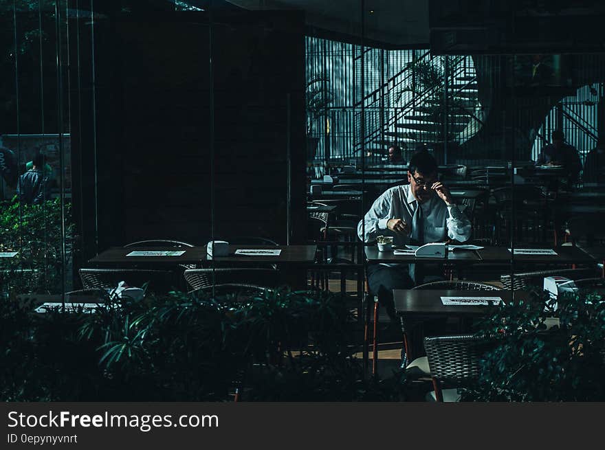 Man Seating Beside Desk Near Door