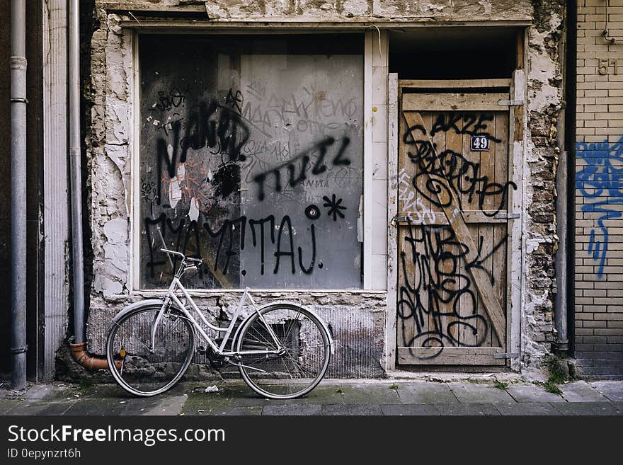 White Cruiser Bicycle Parked in Front of White Concrete House