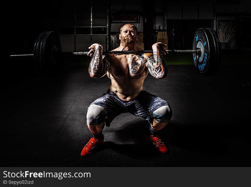 Man in Black Shorts Carrying Adjustable Barbells