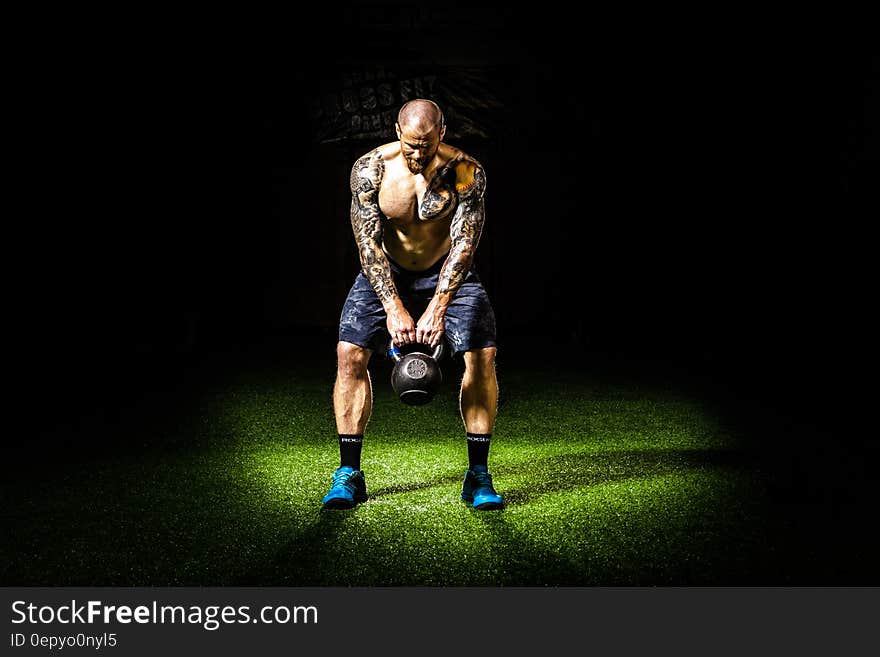 Man in Blue Shorts Carrying Brown Exercise Equipments