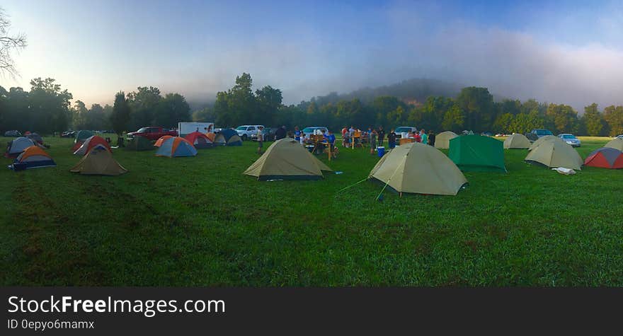 Tents on Green Grass Field Near Mountain