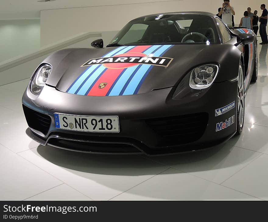 A black Martini Porsche racing car as an exhibit in a museum.