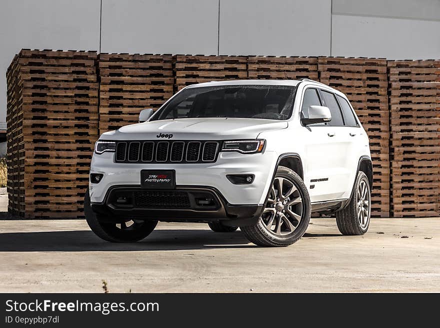 White Jeep Grand Cherokee and material stacks in the background.