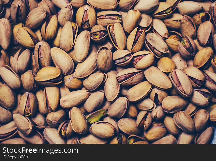 Close up of stack of pistachio nuts in shell.