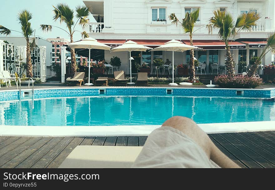 Person Relaxing Near a Swimming Pool