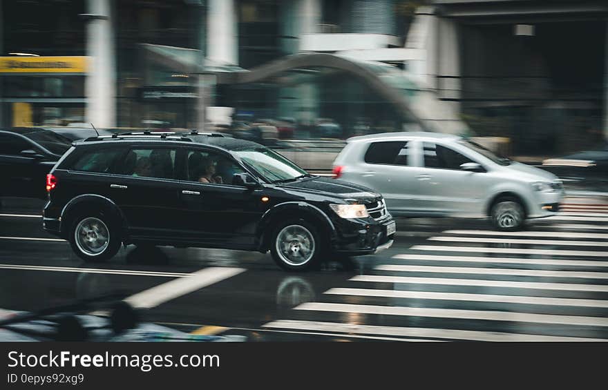 Black Suv Beside Grey Auv Crossing the Pedestrian Line during Daytime