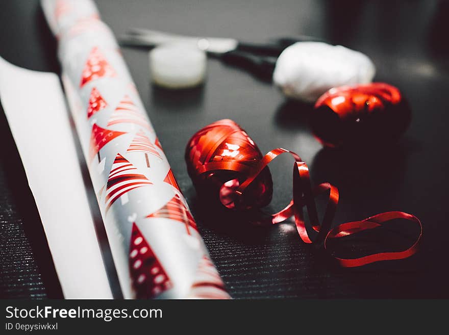 Close up of roll of Christmas wrapping paper with ribbons.