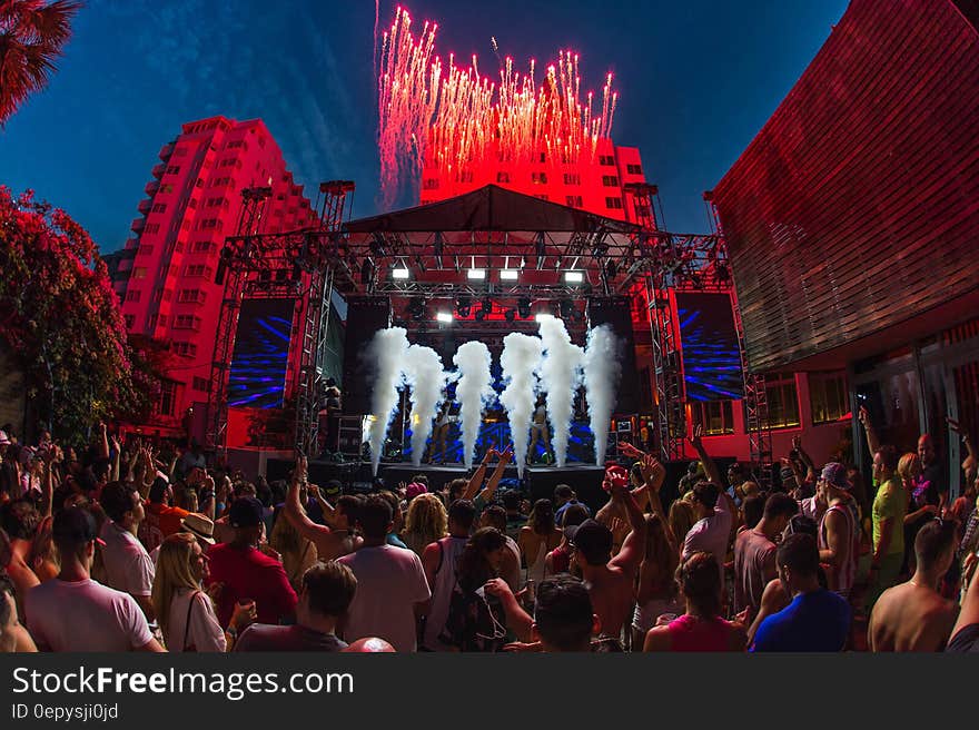 Concert goers in outdoor plaza in front of stage at night. Concert goers in outdoor plaza in front of stage at night.