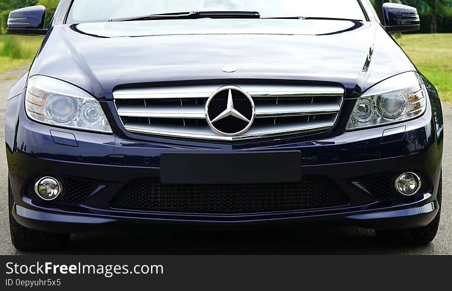 Blue mercedes Sedan Near Green Grass Field during Day Time