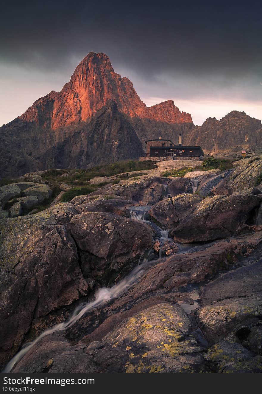 House in foothills of rocky butte in Badlands, USA with mountain stream. House in foothills of rocky butte in Badlands, USA with mountain stream.