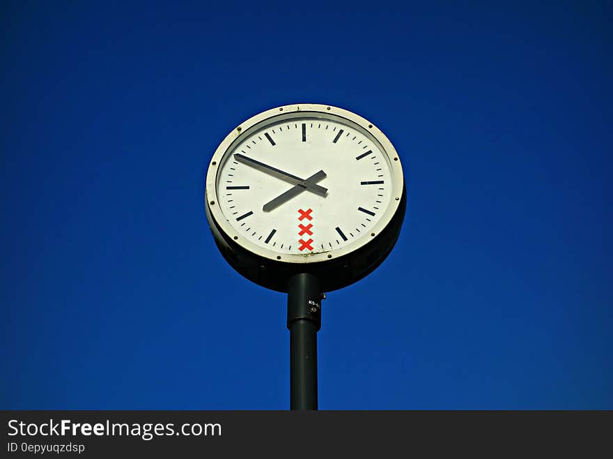 White and Black Round Top Analog Pedestal Clock Low Angle View