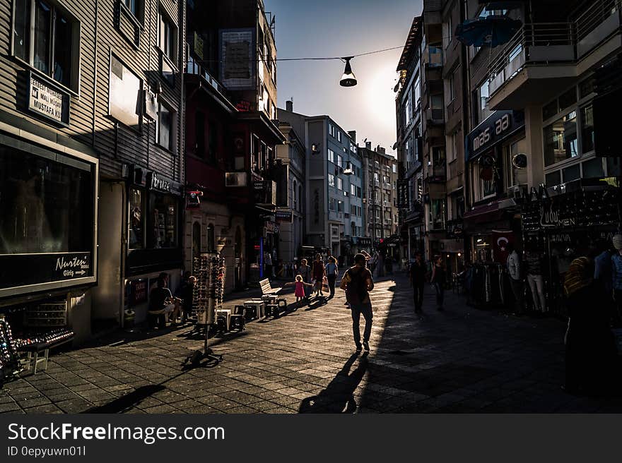 People Walking on Street Between High Rise Building