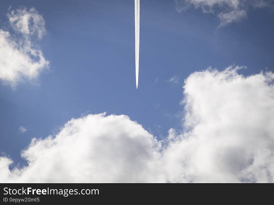 Airplane streaking across blue skies on sunny day. Airplane streaking across blue skies on sunny day.