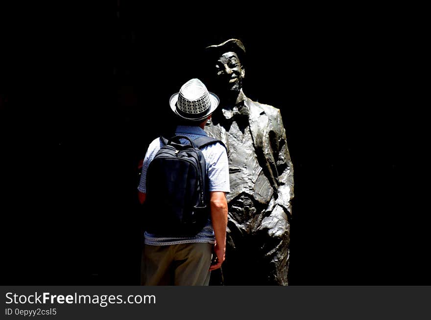 Man Standing in Front of Statue Photo