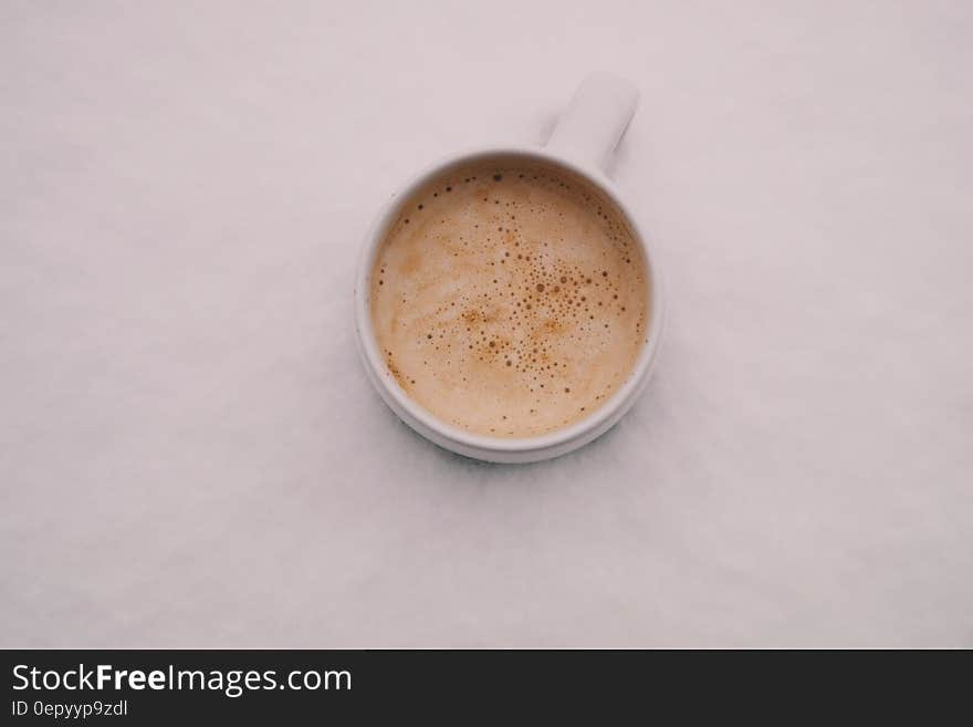 A cup of espresso with milk on a white background.