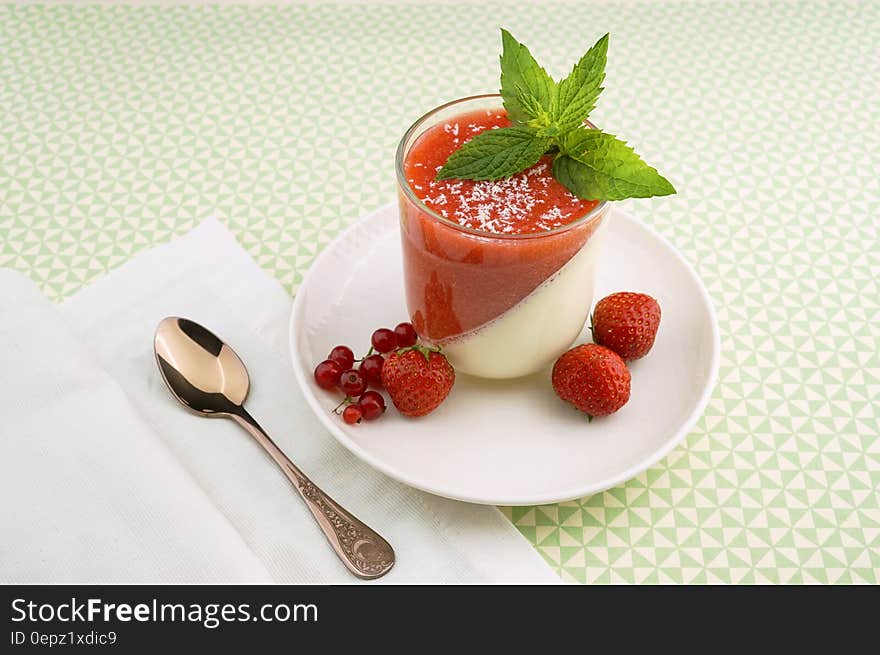 Strawberry parfait in glass with fresh berries and mint sprig.