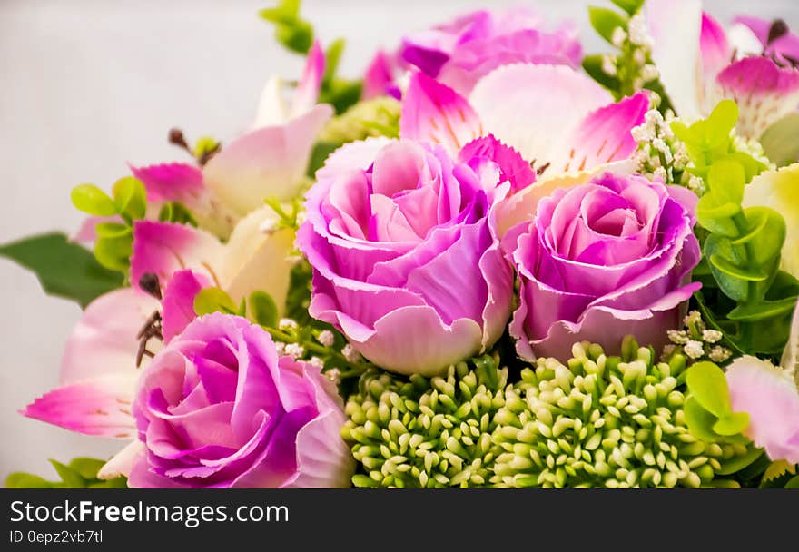 A close up of a flower arrangement with pink roses.