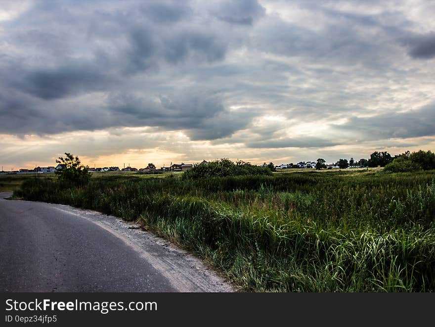 A cloudy sky over a grassland next to a highway. A cloudy sky over a grassland next to a highway.