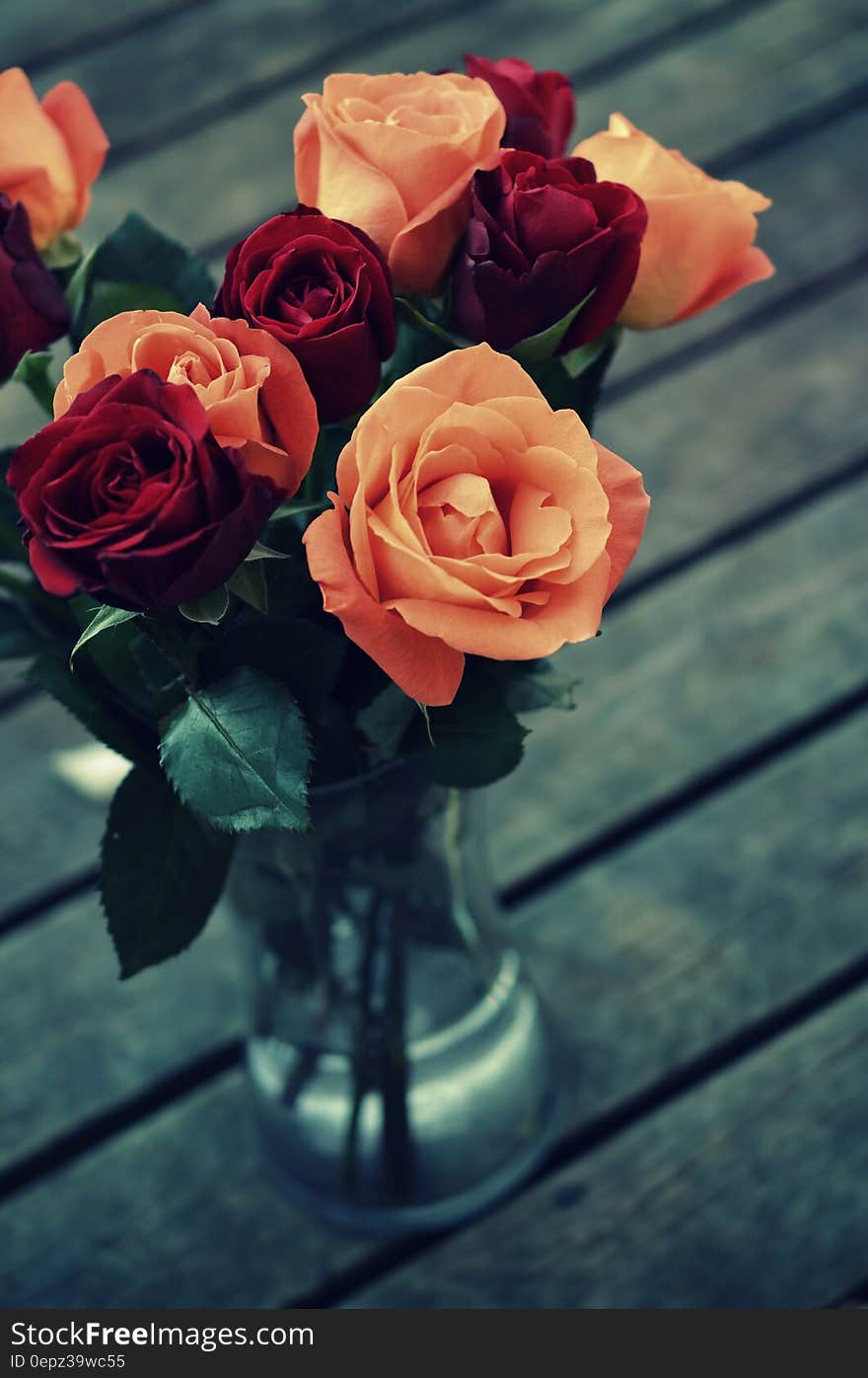 A bunch of colorful rose flowers in a glass vase. A bunch of colorful rose flowers in a glass vase.